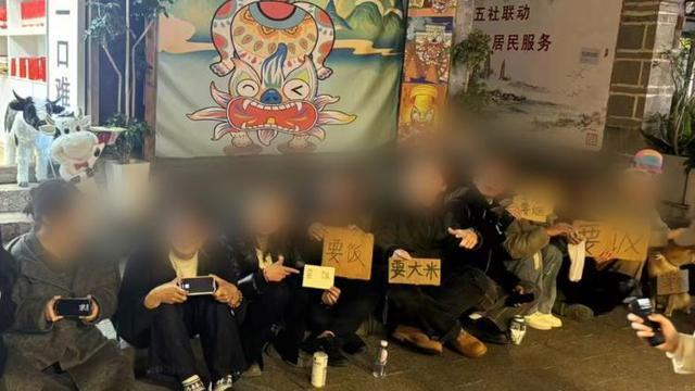 年轻人街头摆要饭牌子引热议 行为艺术惹争议